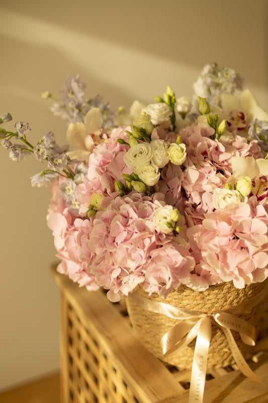 L size basket with hydrangeas, lisianthus, delphinium and orchids